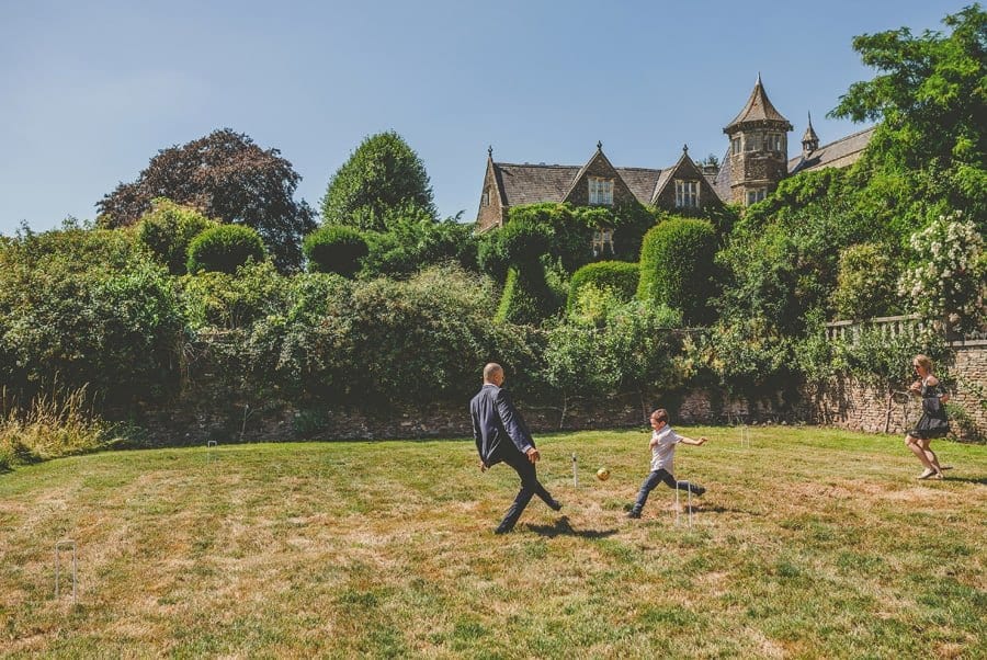 A wedding guest plays football with his son and his wife outside the estate of Hanham Court