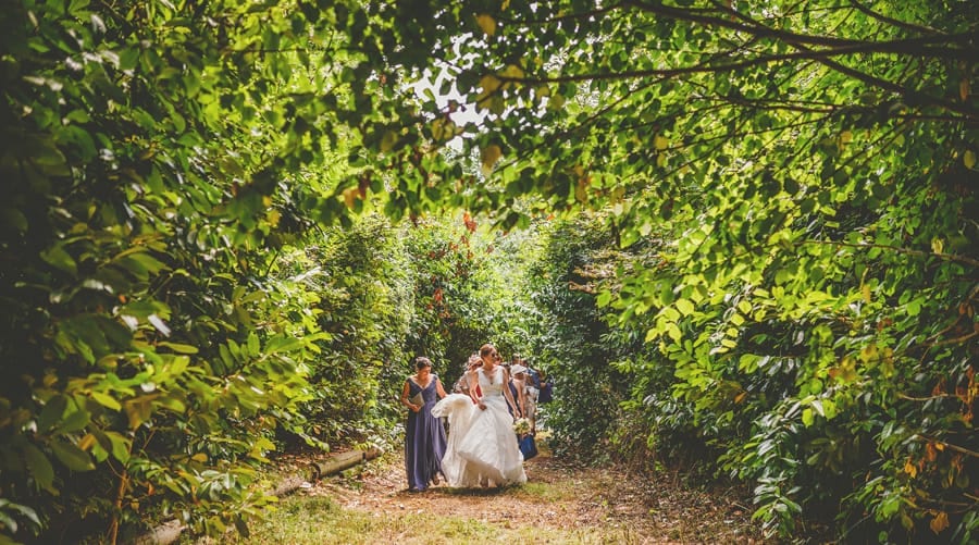 The bride walks through the woods with her bridesmaids towards Hanham Court