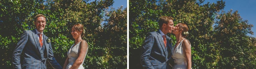 The bride and groom kiss each other during the outdoor ceremony
