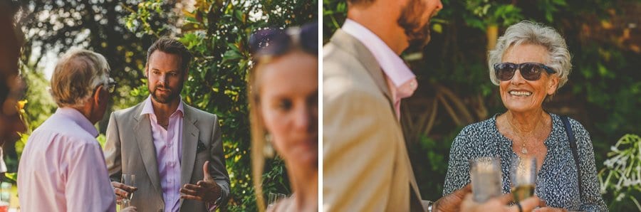 Wedding guests chat to each other in the gardens at Hanham Court