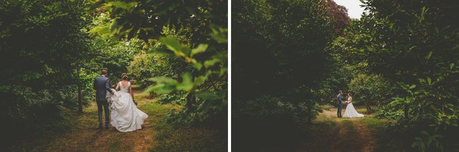 The bride and groom walk through the woods at Hanham Court