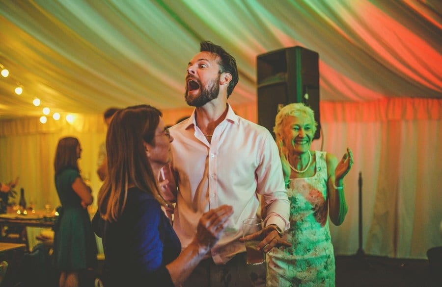 A wedding guest dancing with his wife shouts across the dancefloor