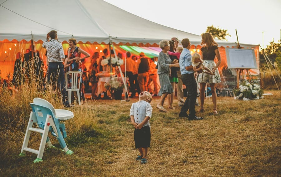 A little boy looks up to the sky outside the marquee at Hanham Court