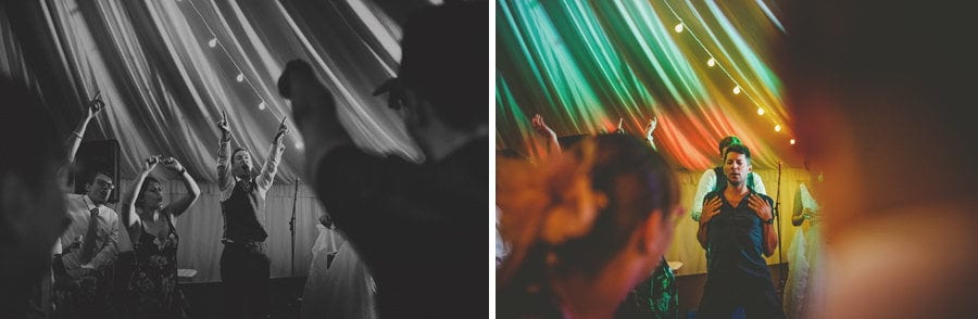 The groom holds both hands in the air and shouts on the dancefloor