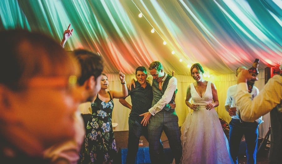 The bride and groom dancing with a wedding guest in the marquee