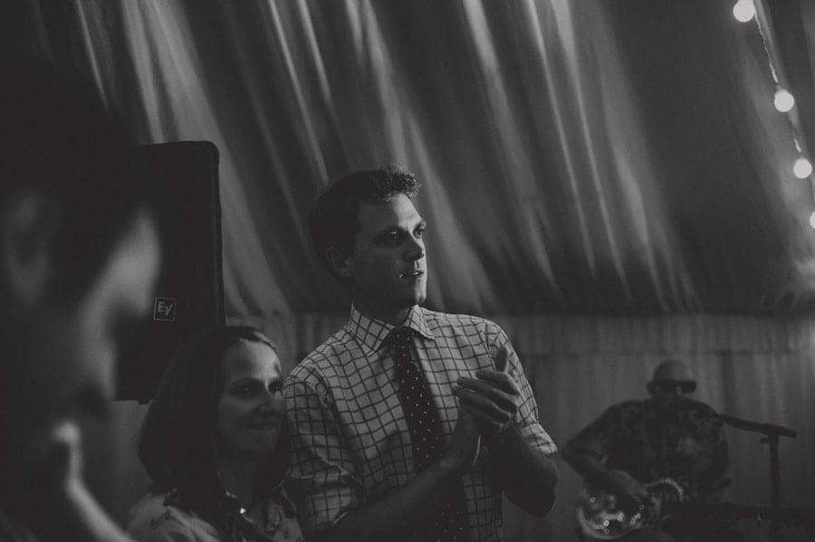 A wedding guest holds his hands together