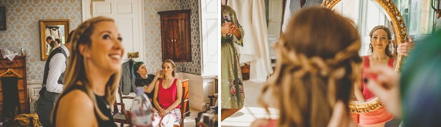 The bride looks in a mirror in the master bedroom at Kings Weston House