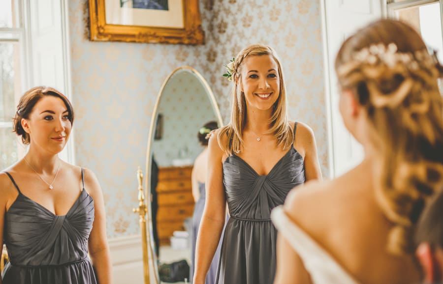 The bridesmaids smile at the bride at Kings Weston House