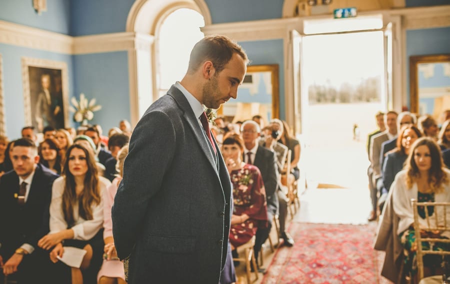 The groom looks at the floor as he nervously awaits the bridal party