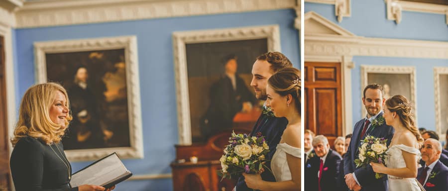 A lady stands in front of the bride and groom and talks to them during the wedding ceremony