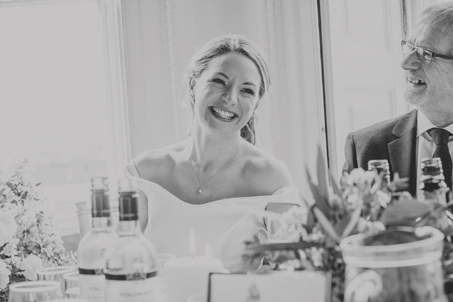 The bride smiles as she listens to the best mans speech at Kings Weston House