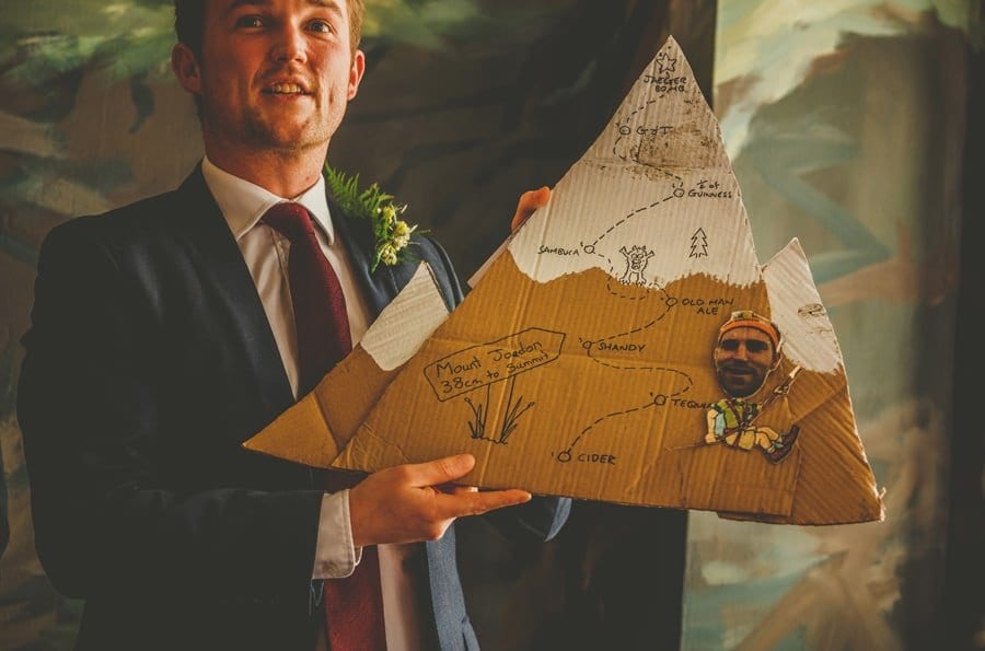 The best man holds up a cardboard cut out for the bride and groom