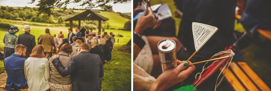 Little Quarme wedding photographer 0023 | somerset-wedding-photographer Wedding guests sit on benches and wait for the start of the outdoor wedding ceremony at Little Quarme Cottages