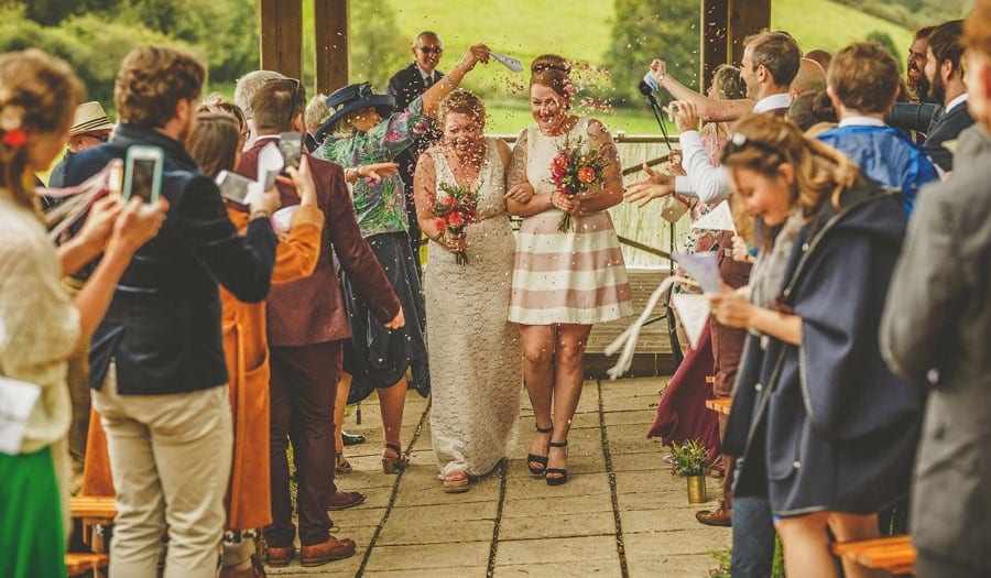 Little Quarme wedding photographer 0034 | somerset-wedding-photographer Confetti lands on the wedding couple as they walk down the aisle together at Little Quarme Cottages