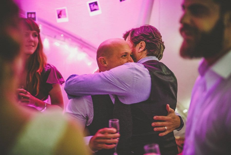 Little Quarme wedding photographer 0062 | somerset-wedding-photographer Two men hug each other on the dancefloor