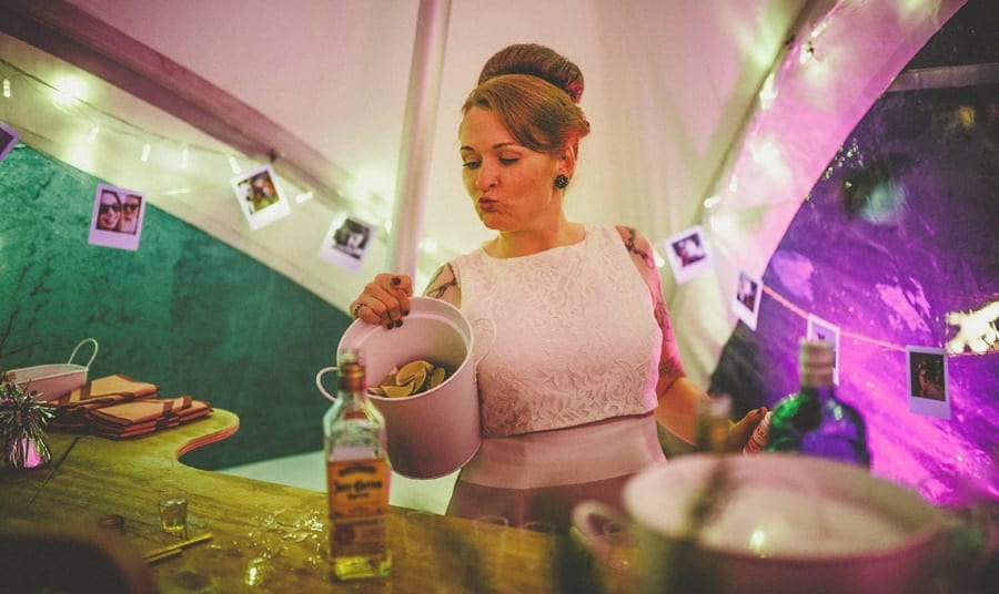 Little Quarme wedding photographer 0063 | somerset-wedding-photographer The bride holds a bucket of limes in her right hand behind the bar of the marquee