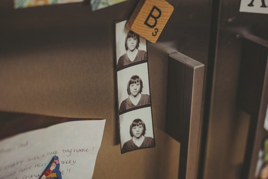 A passport sized black and white photograph of the brides father on a fridge door