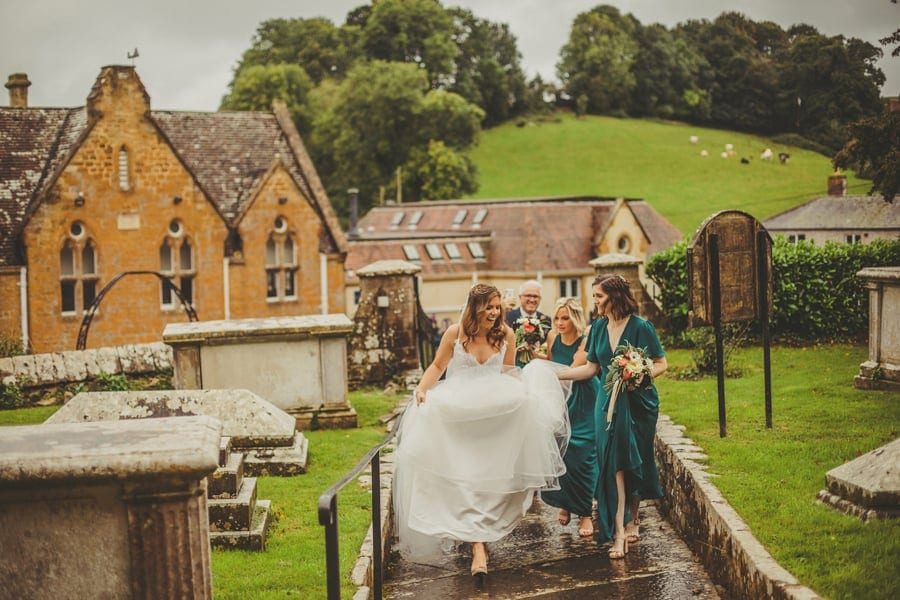The bridal party walk up towards the church