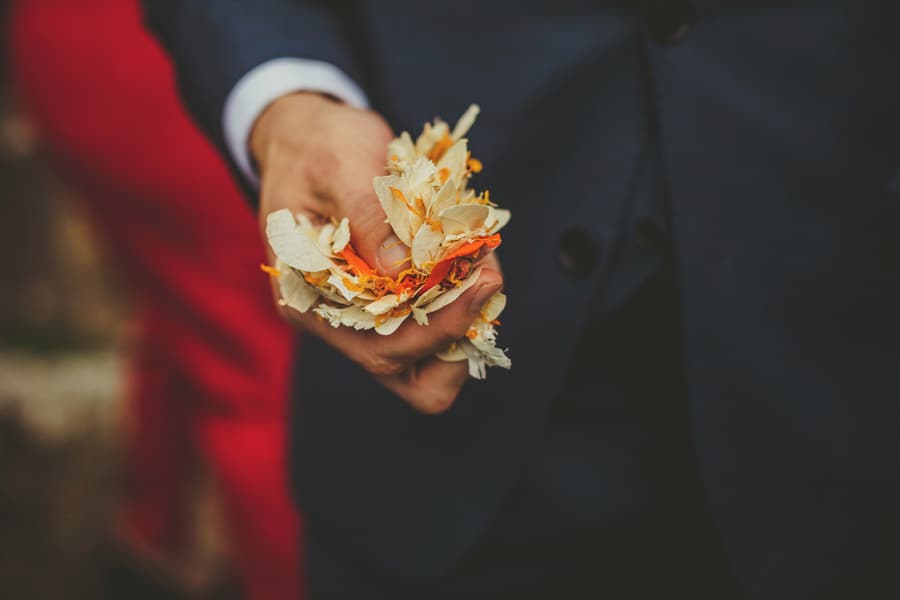 A wedding guest holds confetti in his hand