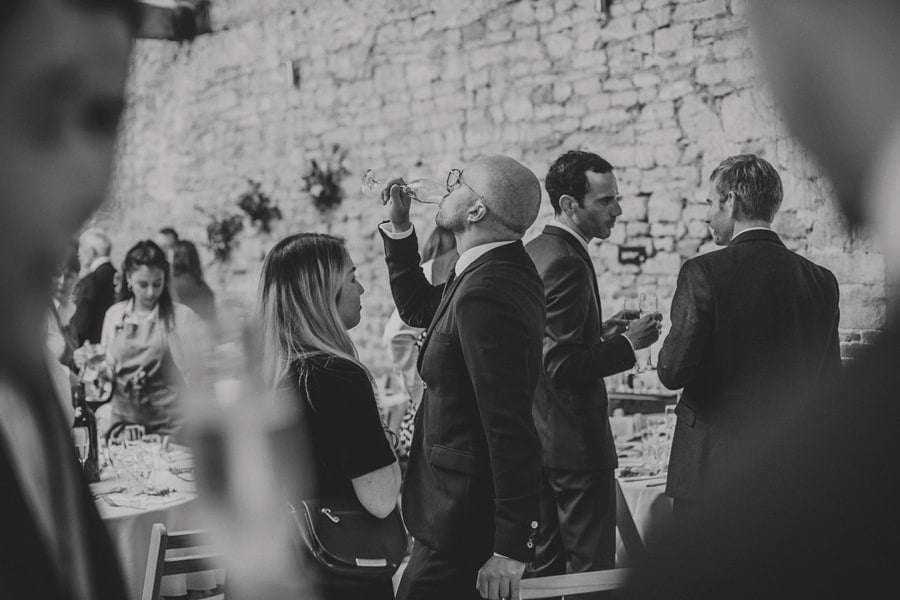 A wedding guest drinks from a flute of champagne