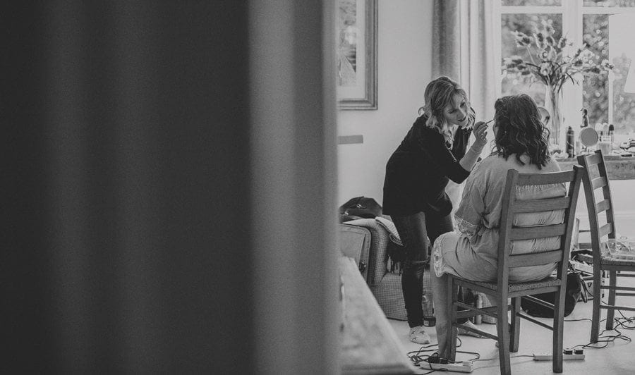 The make up artist attends to one of the bridesmaids