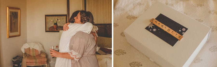 The bride puts her arms around one of her bridesmaids in the kitchen of the house