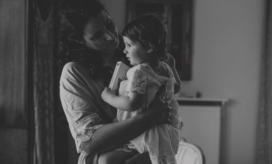 One of the bridesmaids picks up her daughter who is holding her favourite book