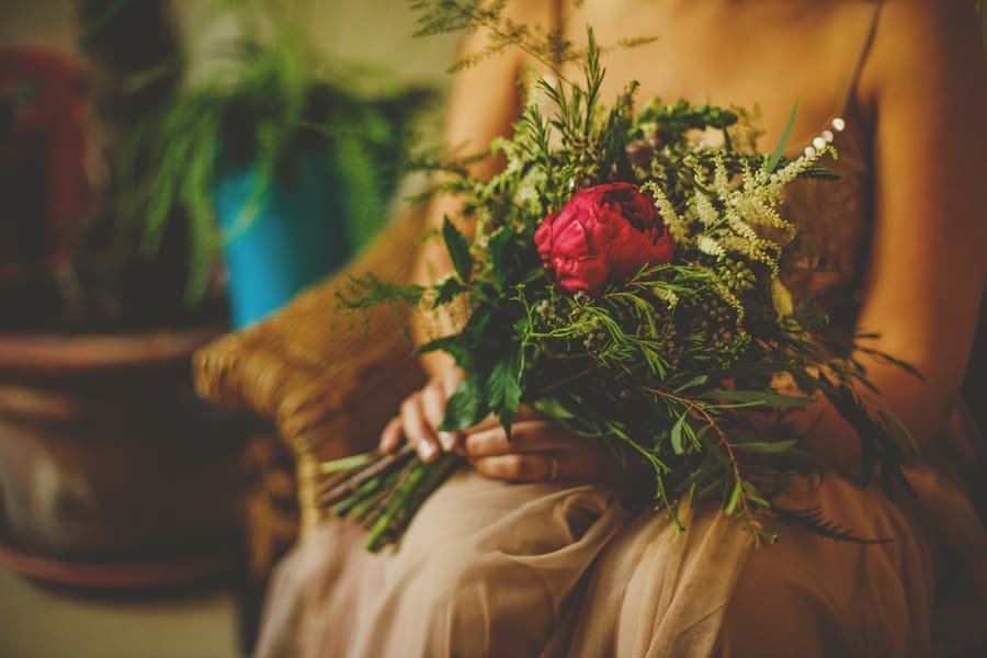 One of the bridesmaids sits down with her bouquet of flowers