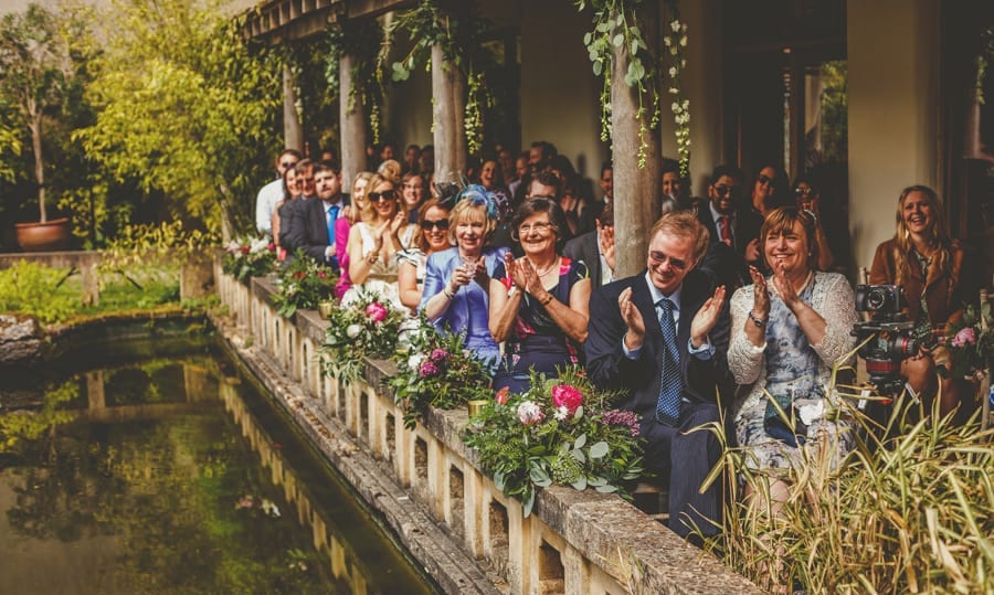 Wedding guests applaud the bride and groom during the wedding ceremony