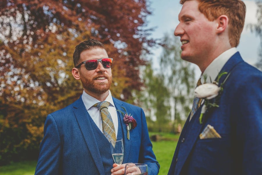 A wedding guest chats with the groom in the garden at the Matara Centre