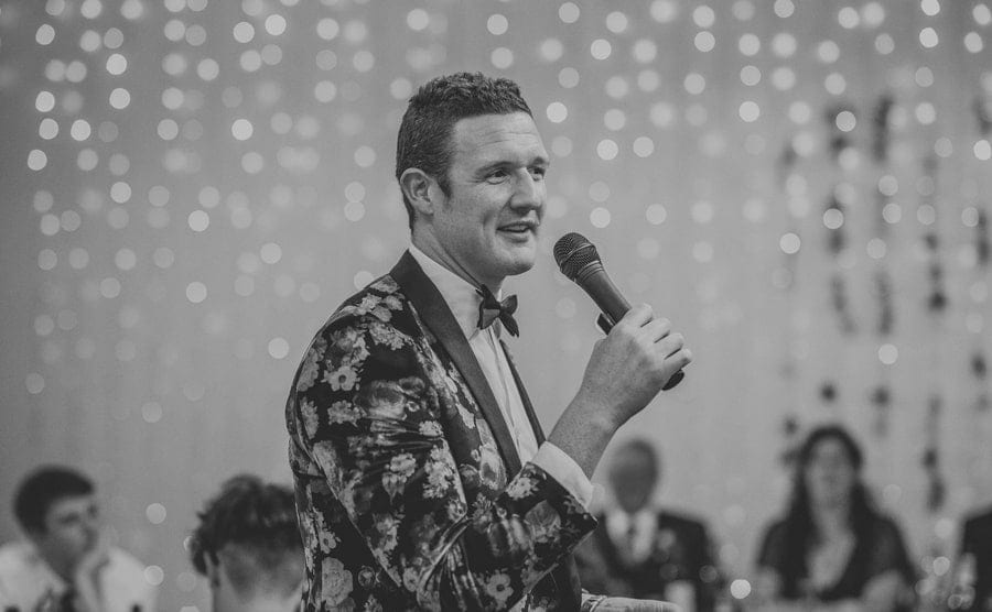 The best man speaks to the wedding guests using a microphone