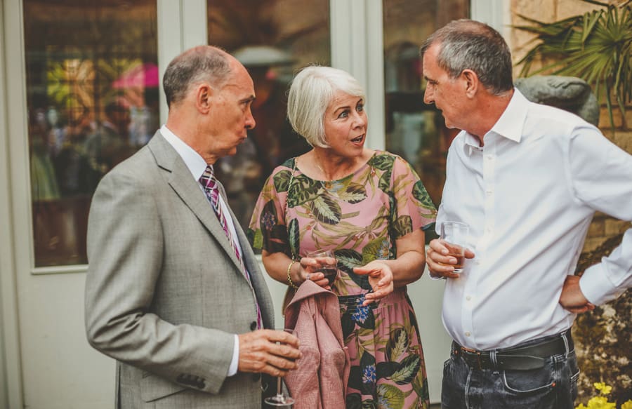 Wedding guests chat amongst each other outside in the gardens at Matara Centre