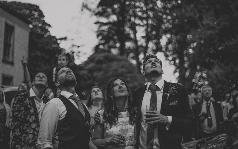 The bride and groom stand outside in the gardens at the Matara Centre and watch the firework display