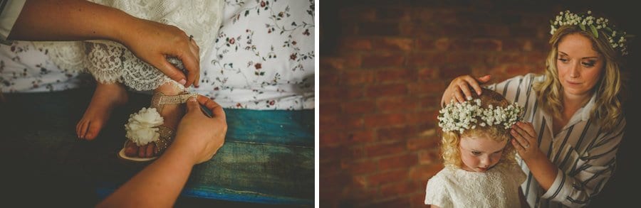 The bride fastens the flower girls strap on her new shoes