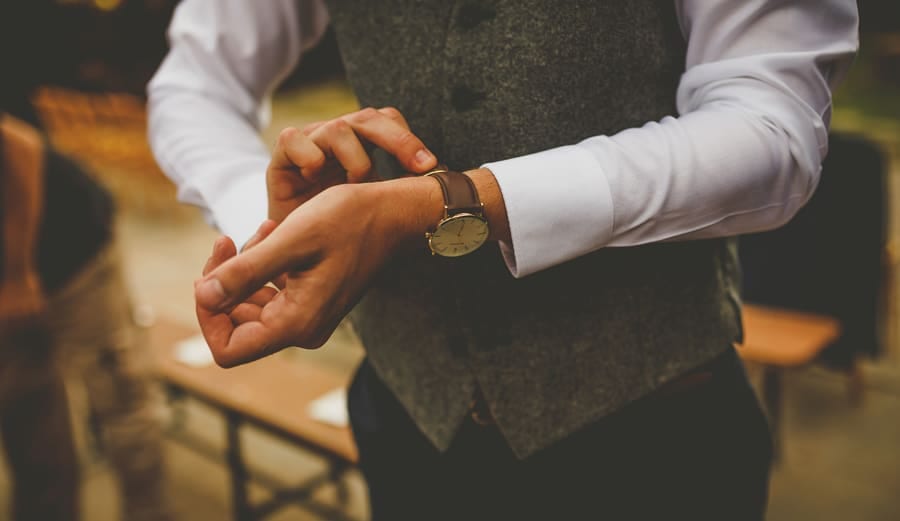 An usher fastens a watch to his wrist