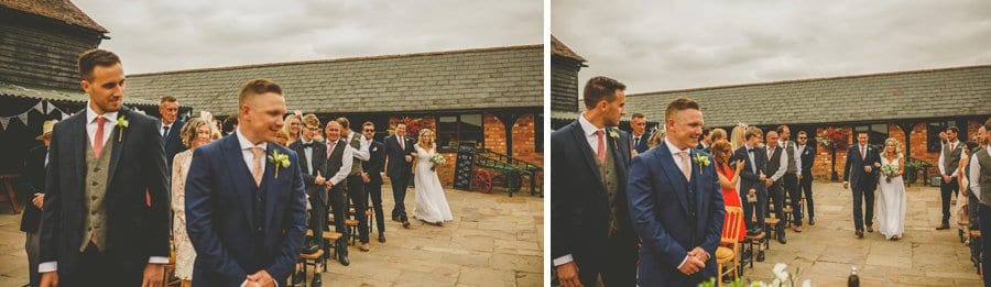 The bride arrives in the courtyard and walks down the aisle towards the groom