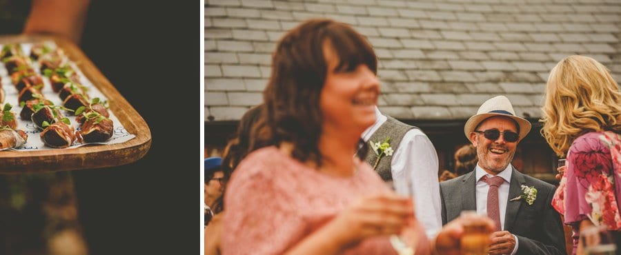 The grooms father laughs with friends and family in the courtyard at Over Barn