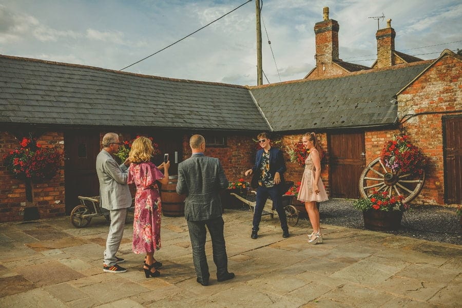 Wedding guests pose for photographs in the courtyard