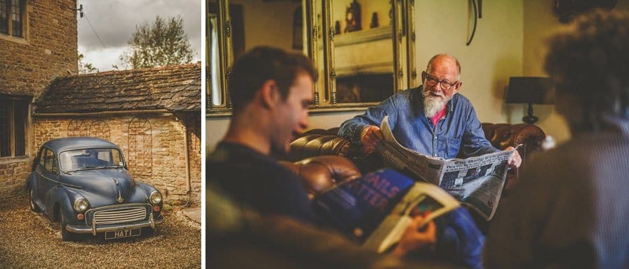 An old car in the courtyard of the cottage and a wedding guest talks to friends sat on a chair with a newspaper