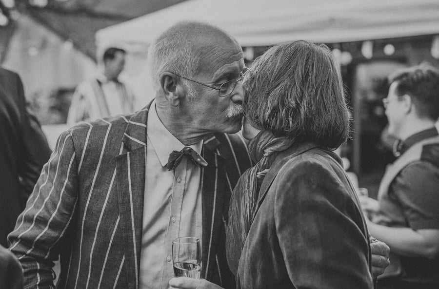 A wedding guest kisses a friend outside Silk Mill studios