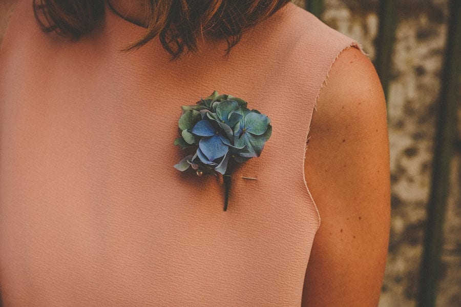 A wedding flower pinned onto the chest of a bridesmaids dress