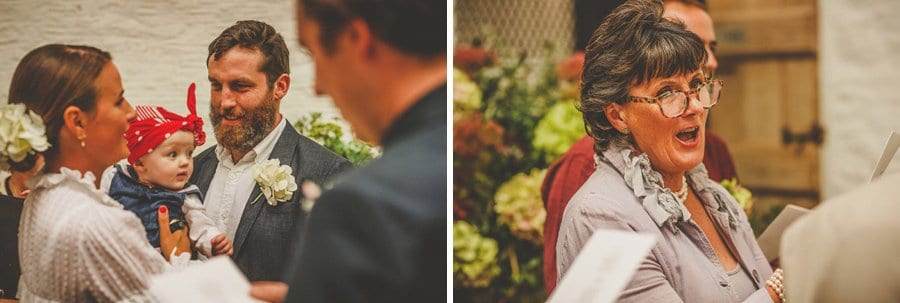 The bride and groom hold their baby girl during the wedding ceremony