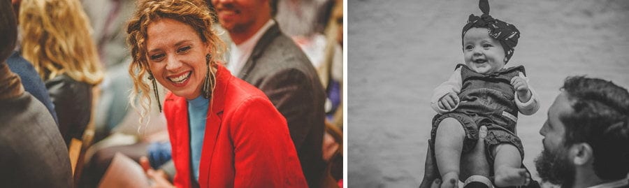 A wedding guest wearing a red jacket laughs during the wedding ceremony
