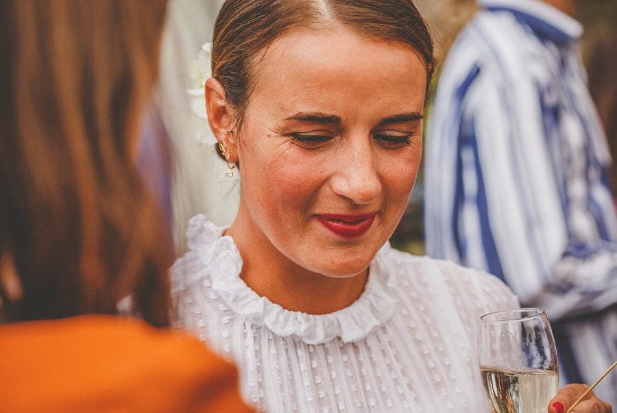 The bride listens to a friend in the courtyard at Silk Mill Studios