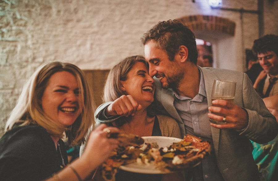 A man puts his arms around his wife as they laugh with one another on the dancefloor