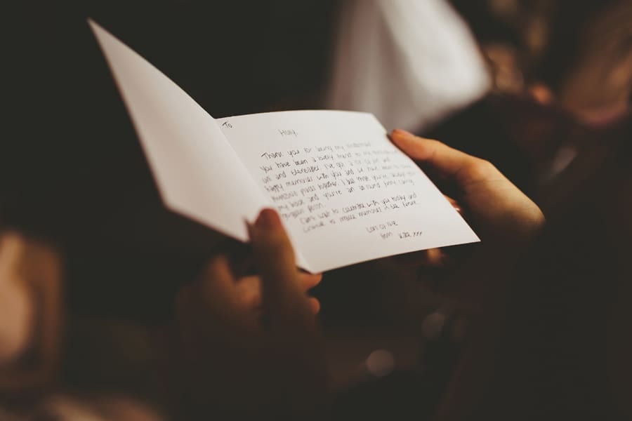 A bridesmaid reads a card given to her by the bride