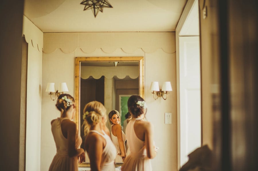 Bridesmaids looking in the mirror and laughing to themselves in the bathroom at Stubton Hall
