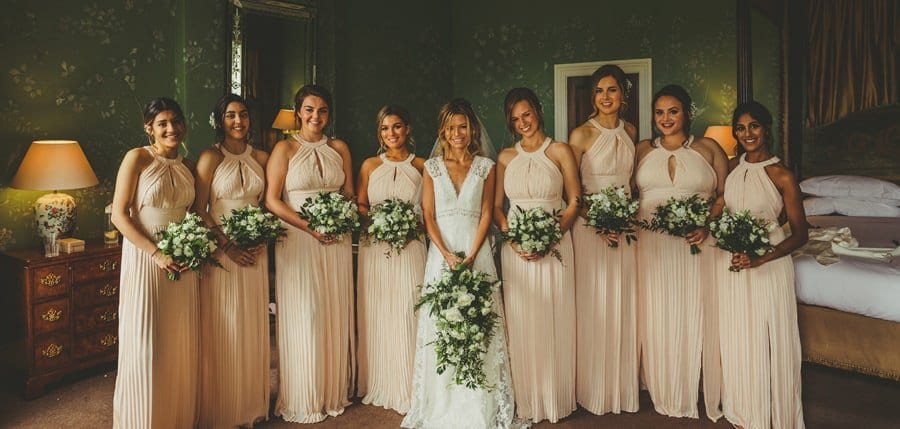 The bride and bridesmaids pose for a photograph in the Master bedroom at Stubton Hall