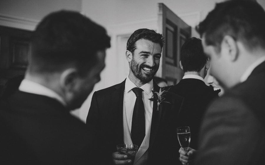 The grooms brother talks amongst the wedding guests