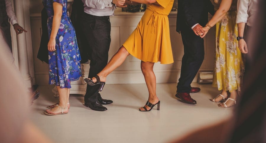 A wedding guest holds out her leg during the ceilidh